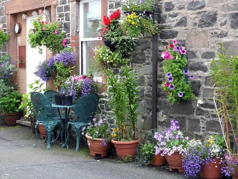 cottage brick stone house with hanging flowers