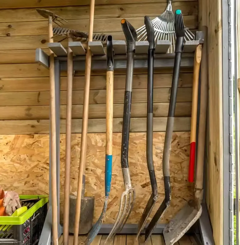 Wooden rack with garden tools and equipment for an organized shed