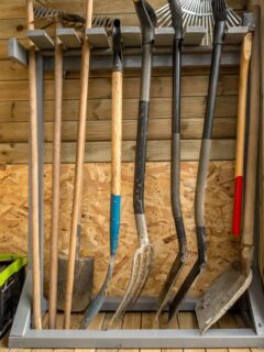 Wooden rack with garden tools and equipment for an organized shed.