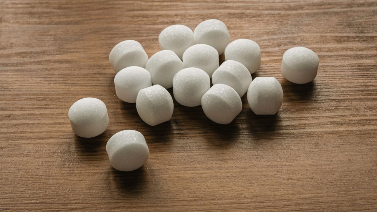 Naphthalene mothballs on wooden background.