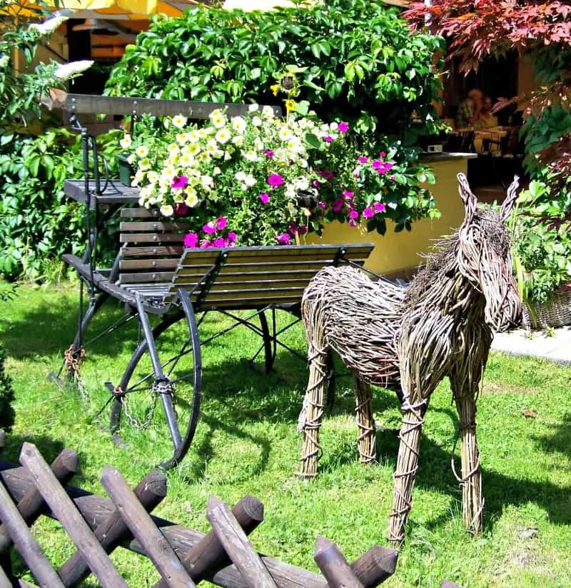 Garden decor: wicher donkey pulling flower filled cart.