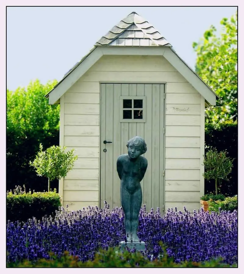 Smal shed with lavender flowers and a statuette