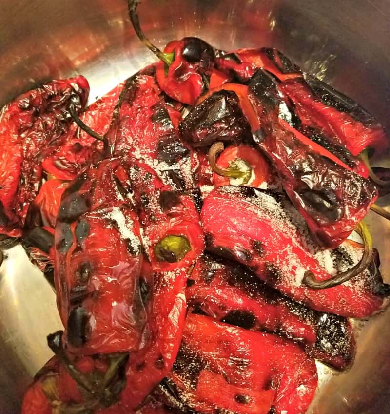 Roasted red peppers sweating in a pot with salt