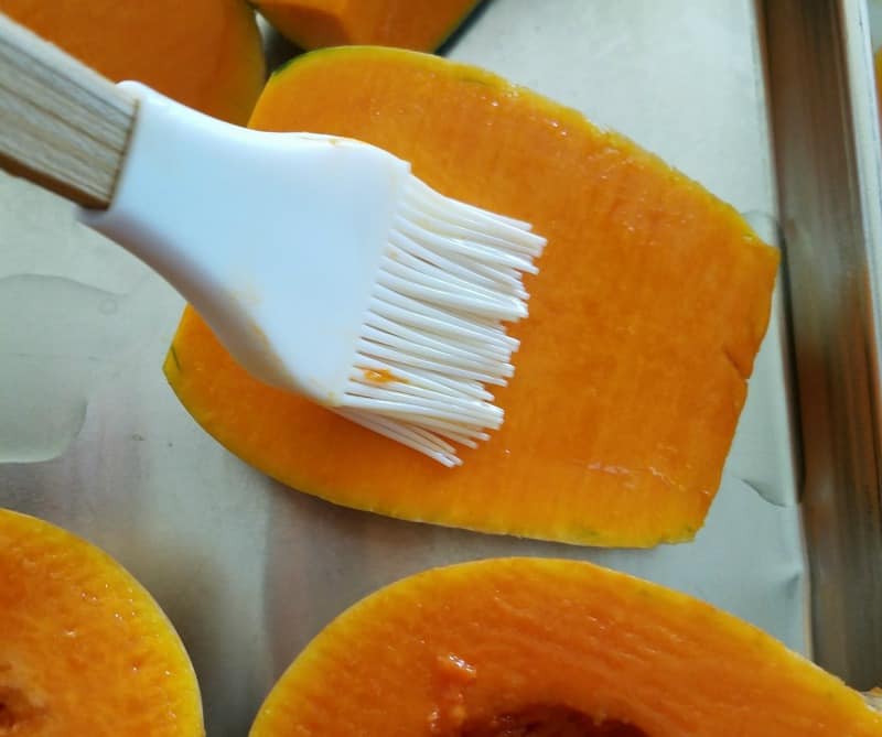 Brushing oil on squash before putting it in the oven