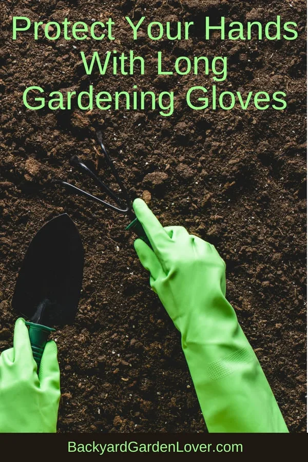 Gloved hand working the soil in the garden