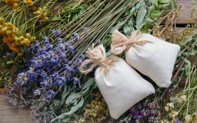 A bunch of healing herbs and sachets on wooden table, ready to make dream herbal pillows