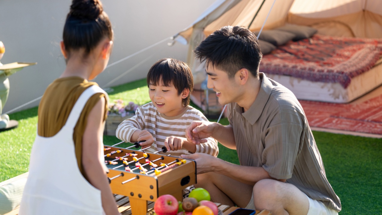 Father and children playing outside in a gazebo