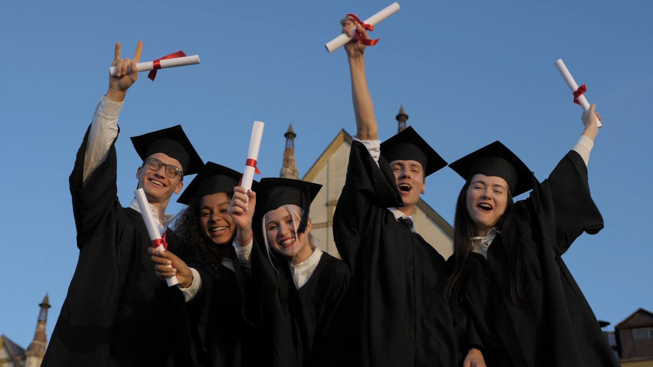 Group of cheerful students wearing graduation gown