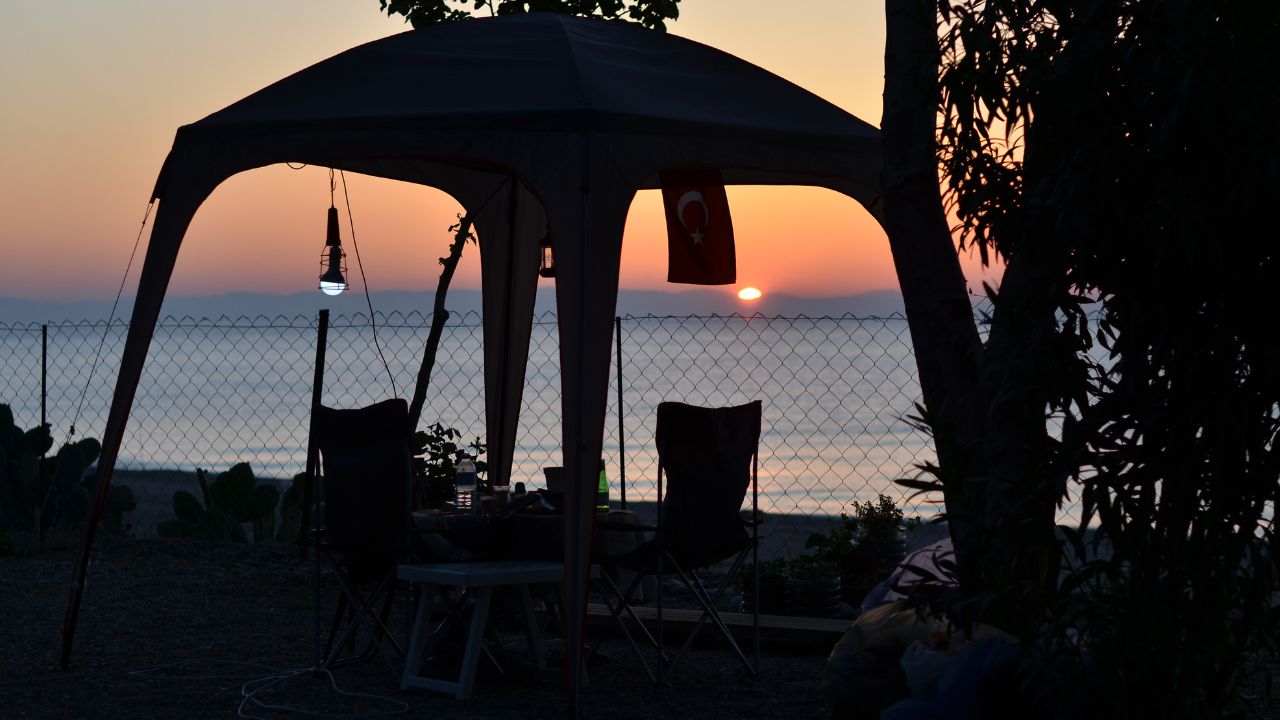 Romantic dinner in a tent on a sandy beach at sunset