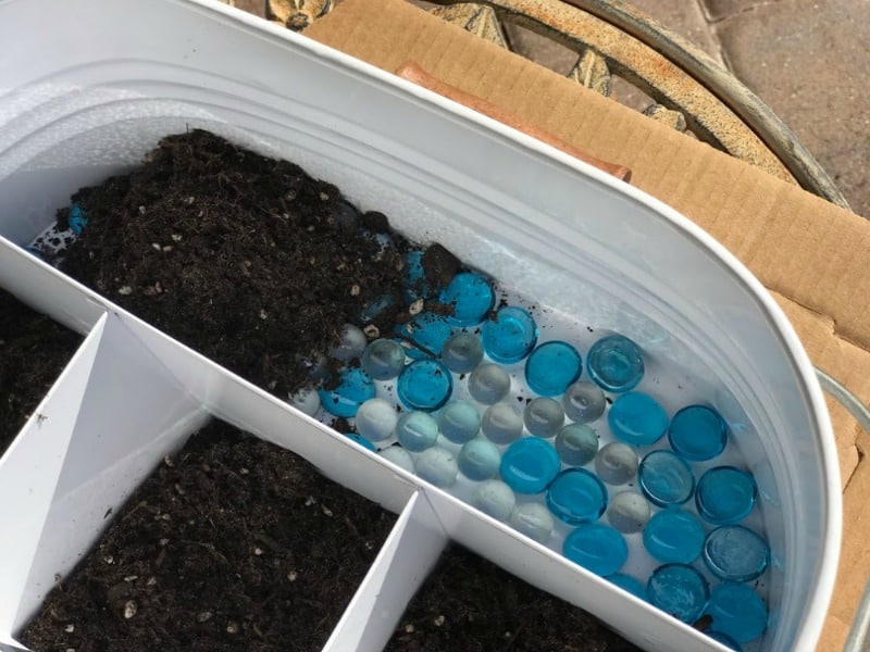 Here I'm adding soil on top of the glass marbles.