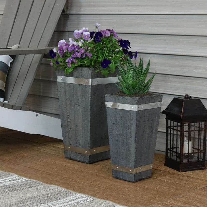 Gray tall planters in front of a wall