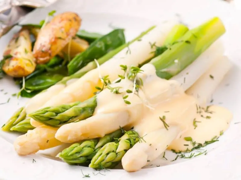 Cooked green and white asparagus with white sauce