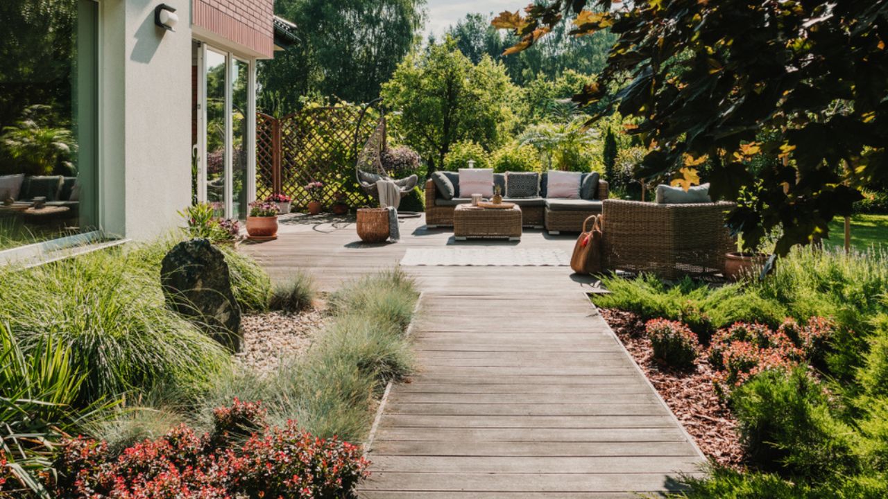 Wooden path to terrace in the garden with trendy garden furniture