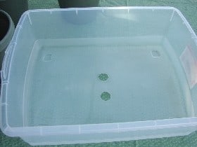 Two holes drilled in the bottom of a Rubbermaid container