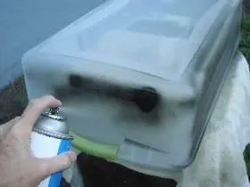Spray painting the bin with black paint