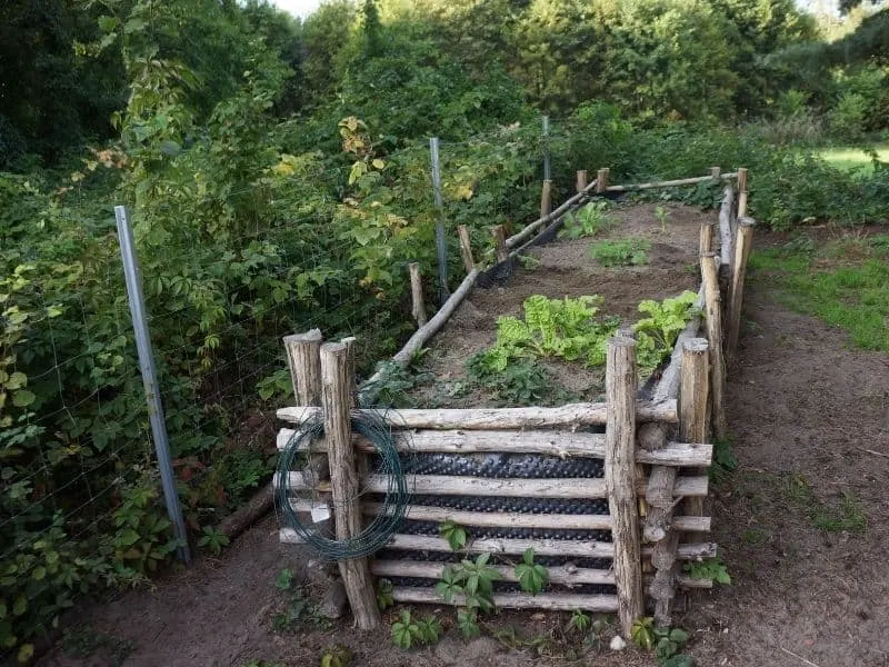 Raised garden bed made from recycled wood logs