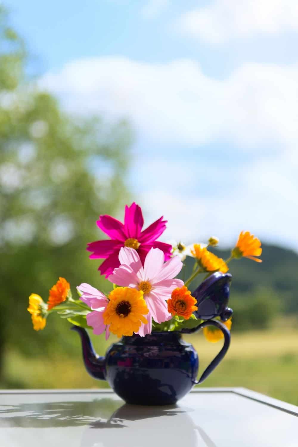 simple bouquet in a dark tea kettle container
