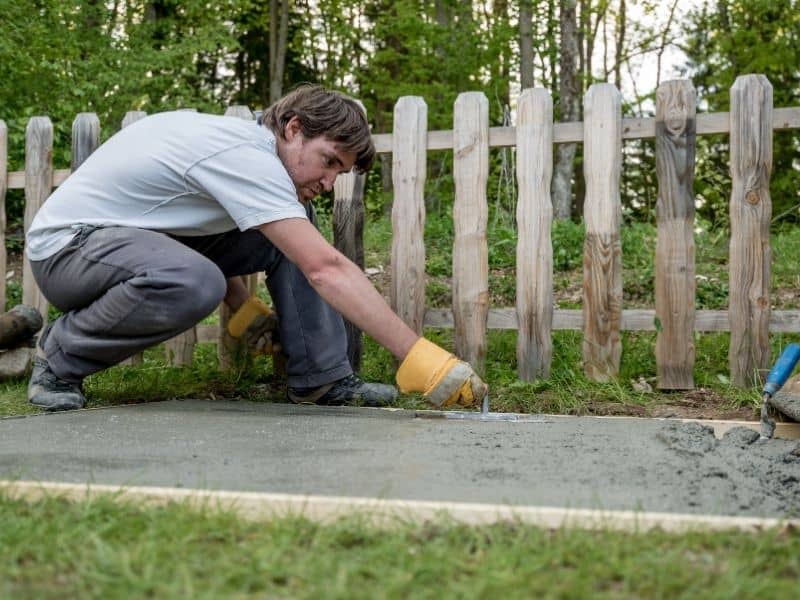 a man building a cement walkway