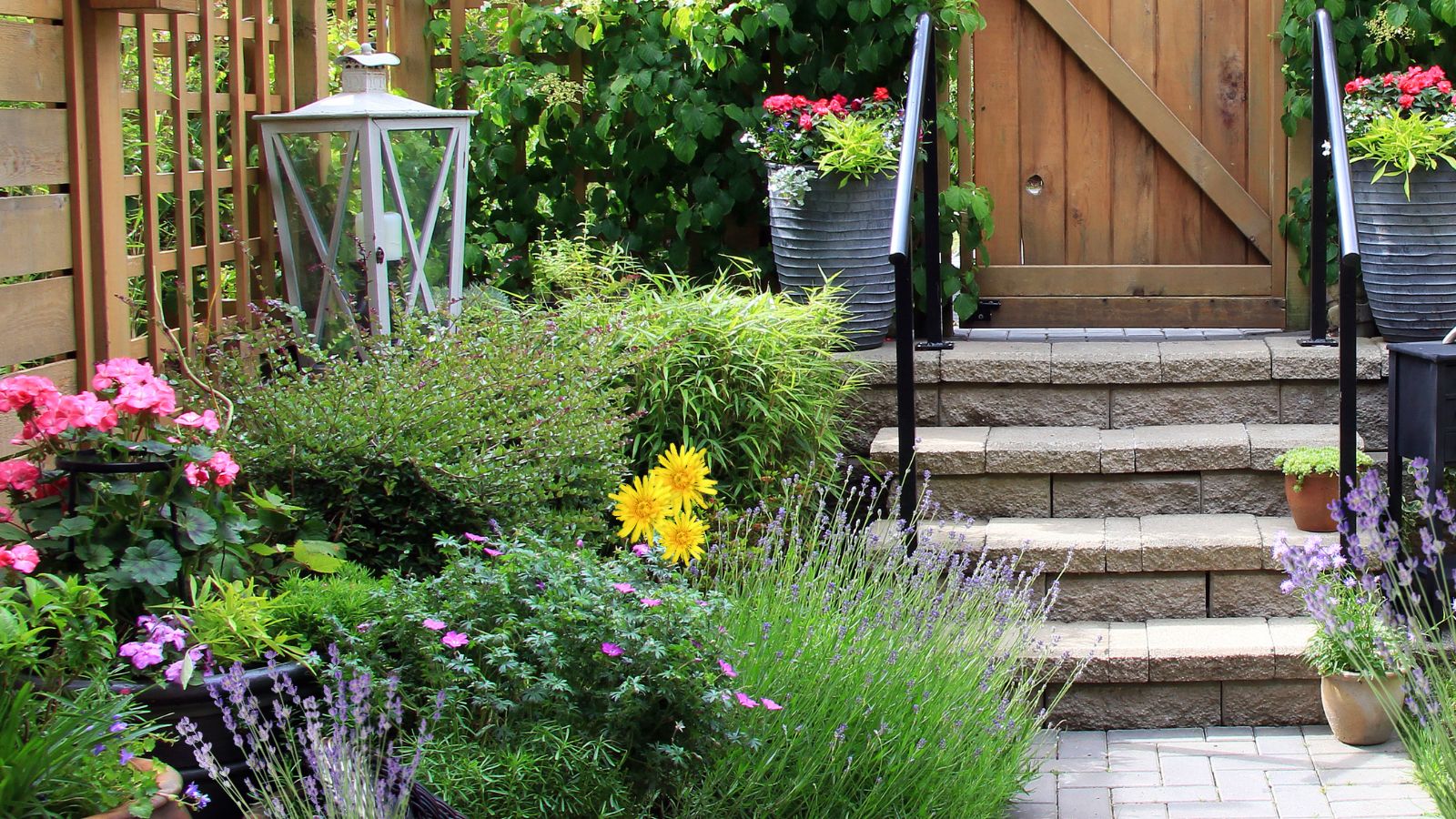 Small backyard garden with flowers, a table, and a chair.