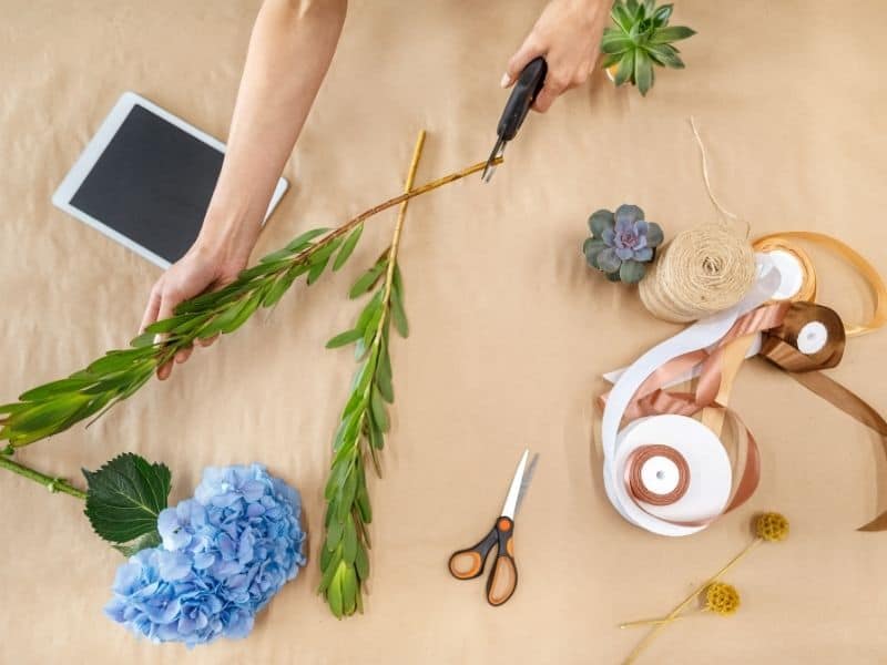 woman cutting flower stem diagonally