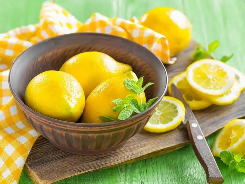 freshly picked lemons in a wooden bowl