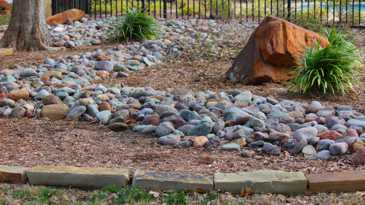 Landscaping with a dry stream and using river rock to accent garden
