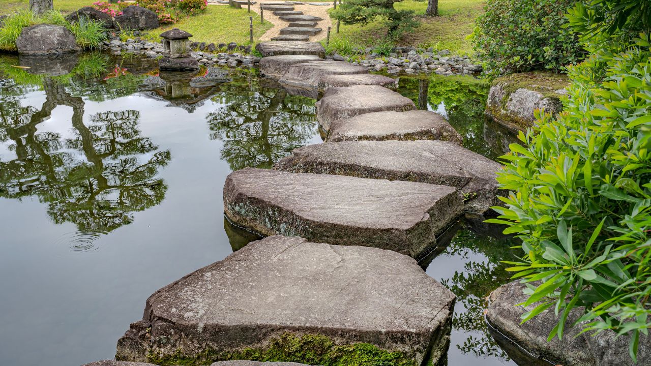 Large flat rocks forming a path over a Japanese pond. Koko-en zen garden near Himeji castle.