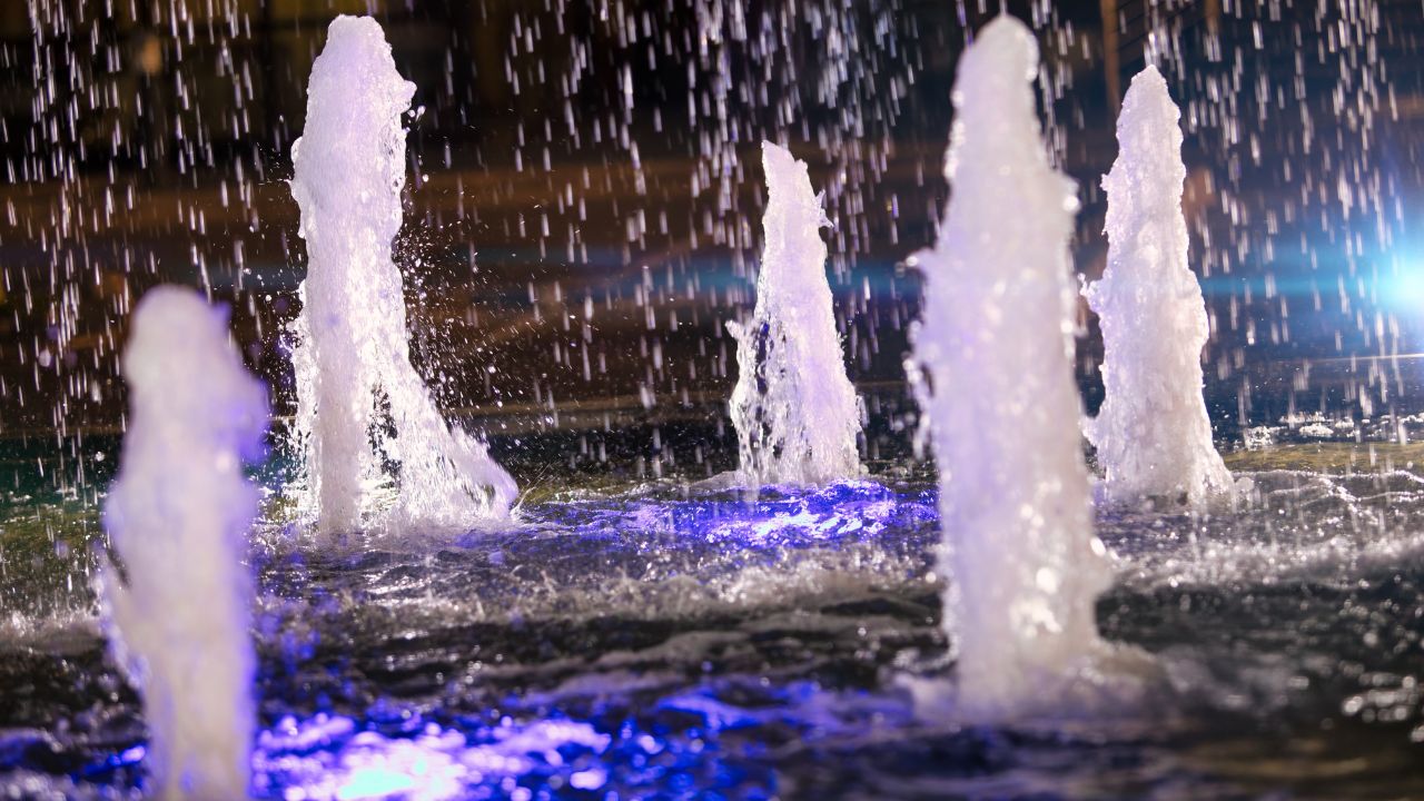 abstract backgrounds, fountain jet or stream of water, bubbles splash seen through a blue light