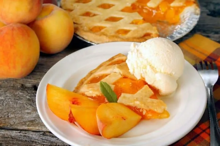 a piece of peach pie and a dollop of ice cream