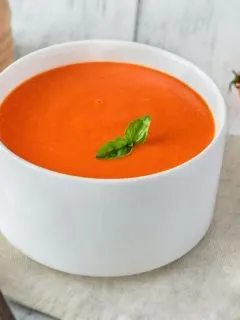creamy tomato soup in a white bowl