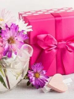 vase with pink flowers and gift wrapped in bright pink paper
