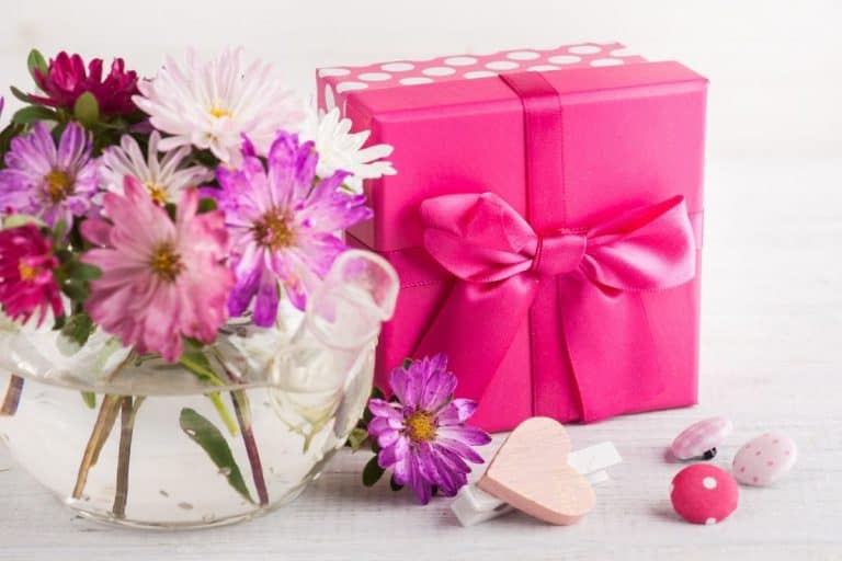 vase with pink flowers and gift wrapped in bright pink paper