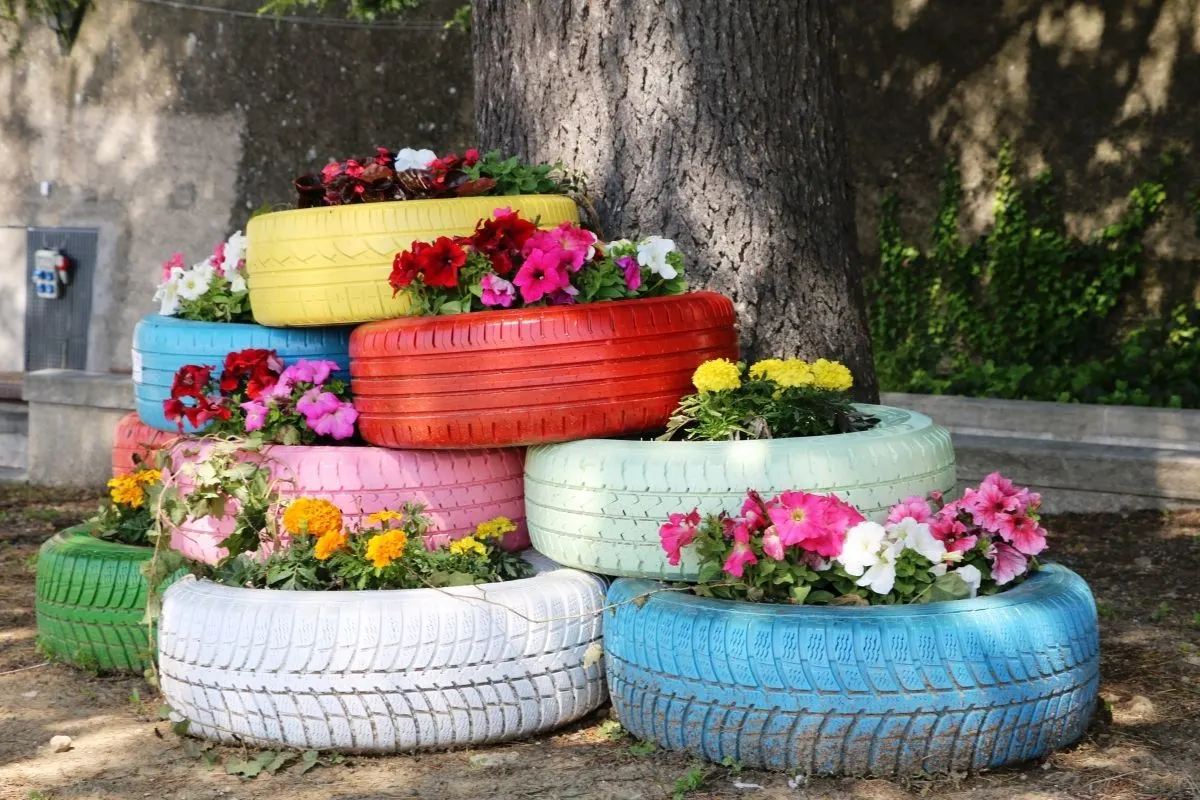 a pile of colorful car tires filled with flowers