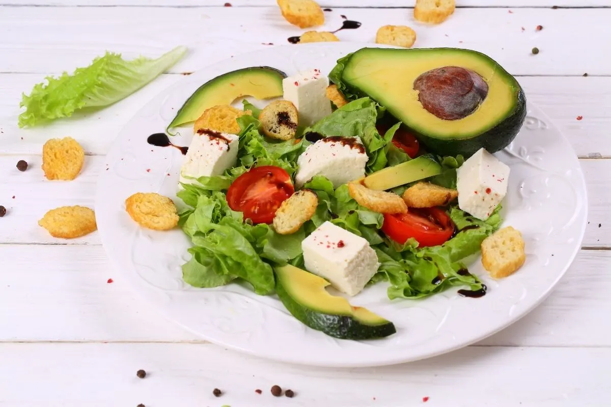 a plate of vegetable salad with avocado