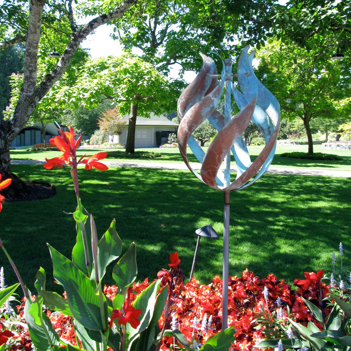 a kinetic sculpture among red flowers.