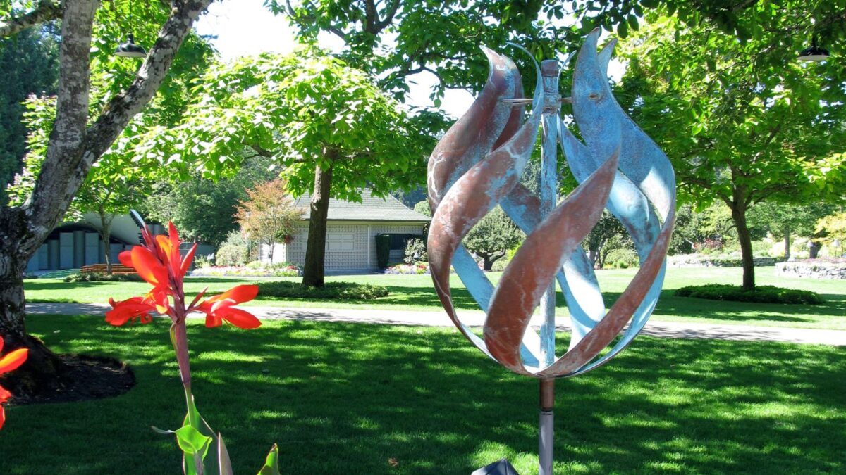 a kinetic sculpture among red flowers.