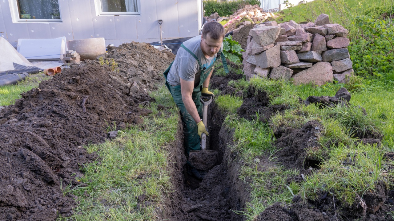 A man Digging ground to prepare for drainage home.
