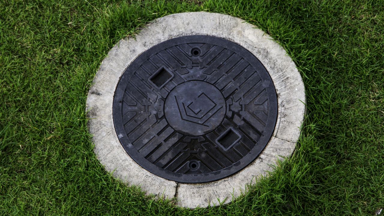 Drains in pasture, septic tank, manhole cover