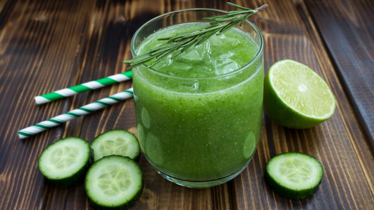 Green cucumber lemonade on the brown wooden background