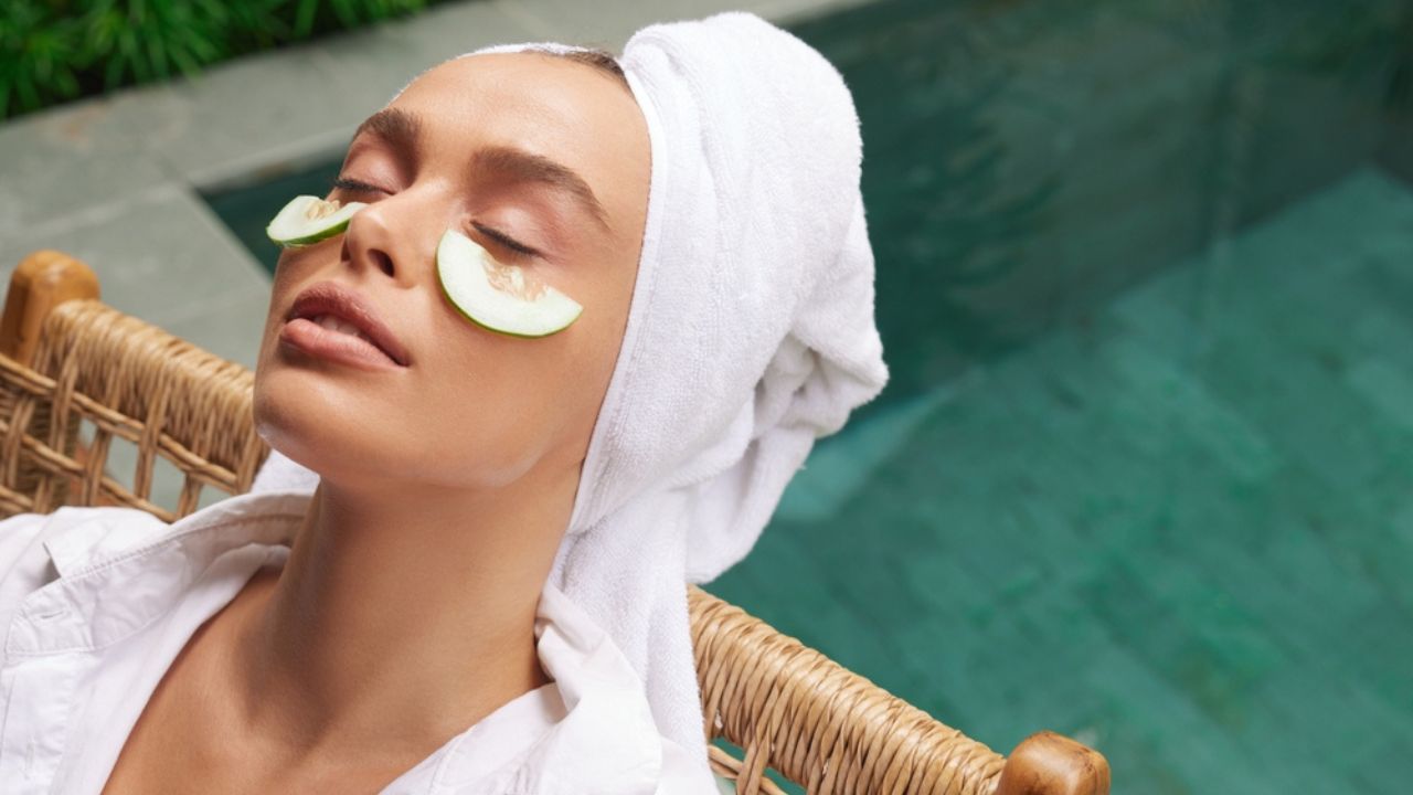 Relaxed Woman With Cucumber Mask. Young Bathrobe Girl Relaxing With Cucumber Slices Under Eyes Near Swimming Pool. Concept of Skincare