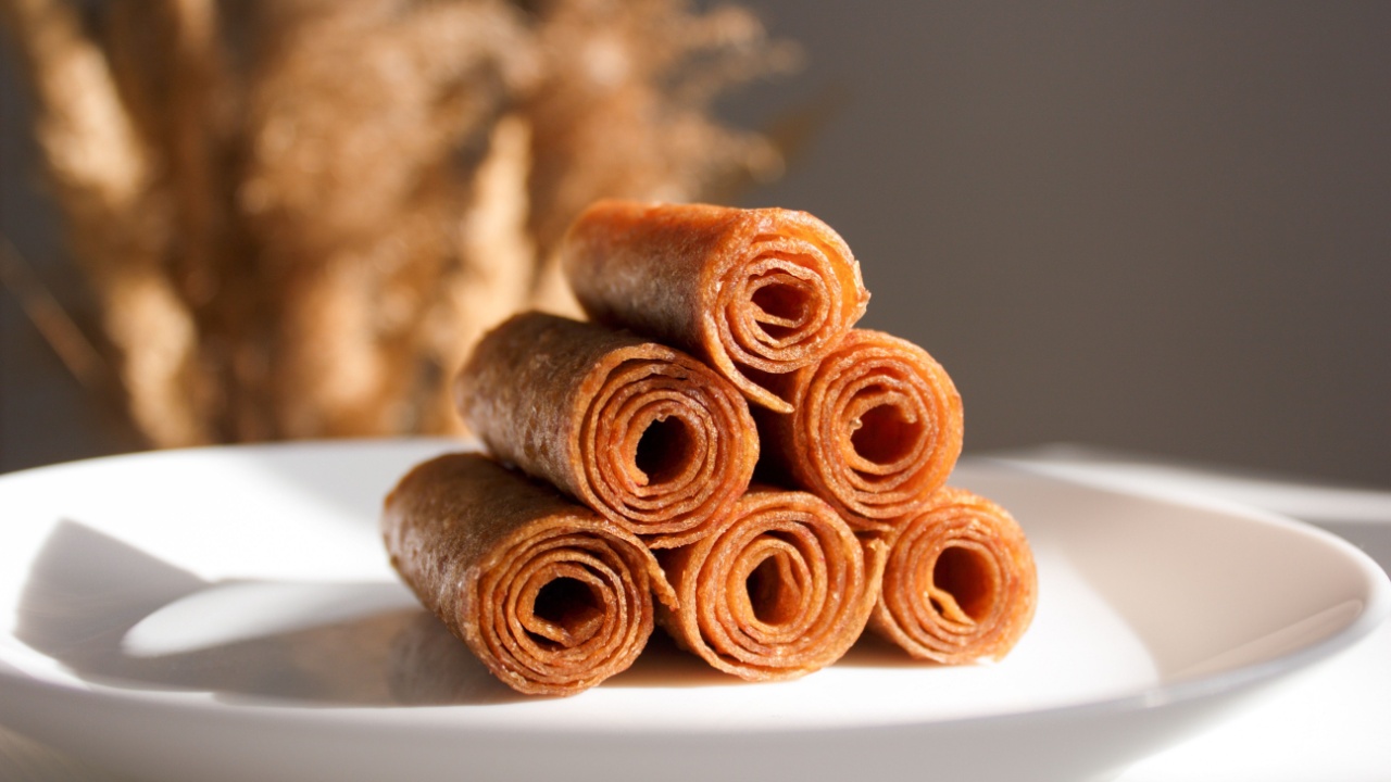 Macro pastille. Fruit leather of apples in rolls (Russian pastila). Background for text and articles on healthy eating. Raw food, vegan sweetness, dessert without sugar and flour.
