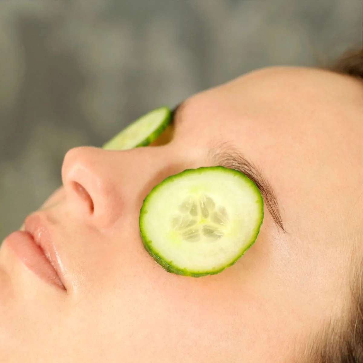 woman relaxinjg with cucumber slices on her eyes