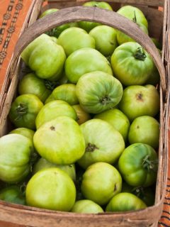 a basked filled with green tomatoes