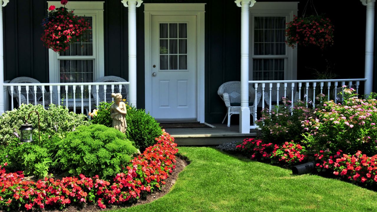 Landscaped front yard of a house with flowers and green lawn