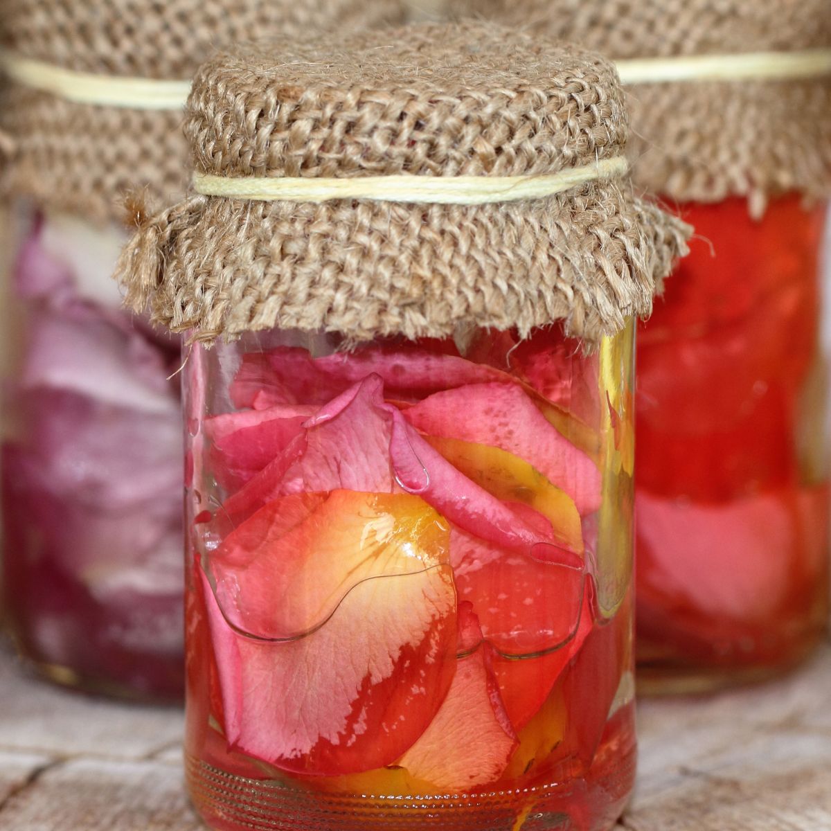a jar filled with rose petals in water.