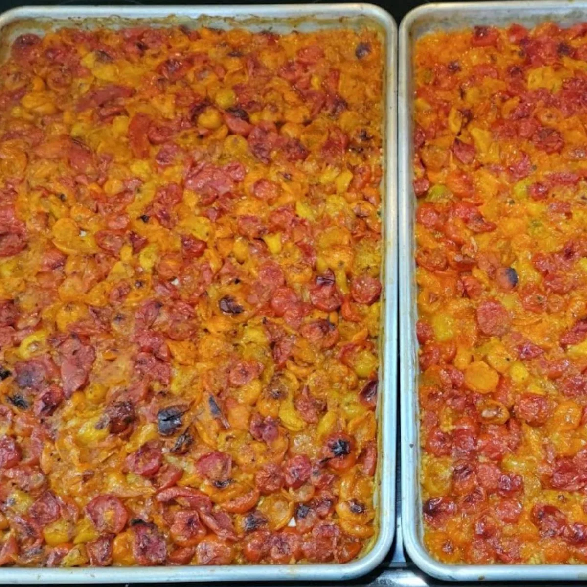 Two sheet pans of freshly roasted cherry tomatoes. 