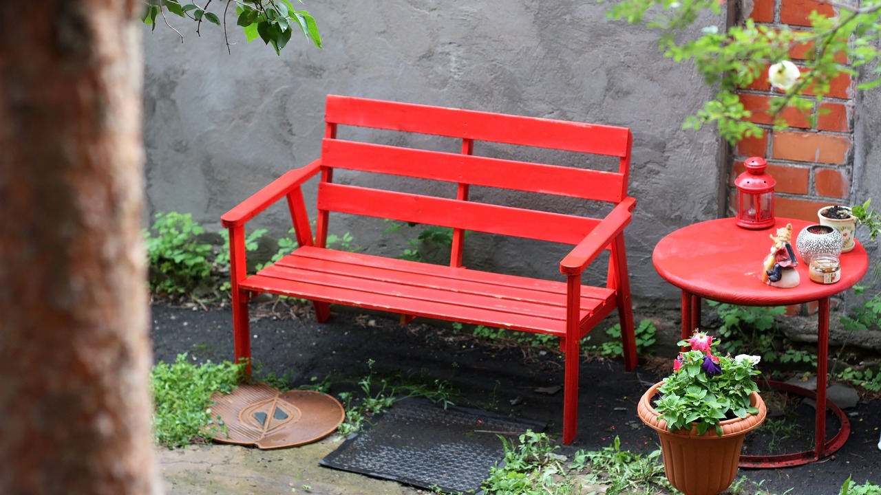 Cozy corner for rest with a red bench in the yard of the house. Top view.