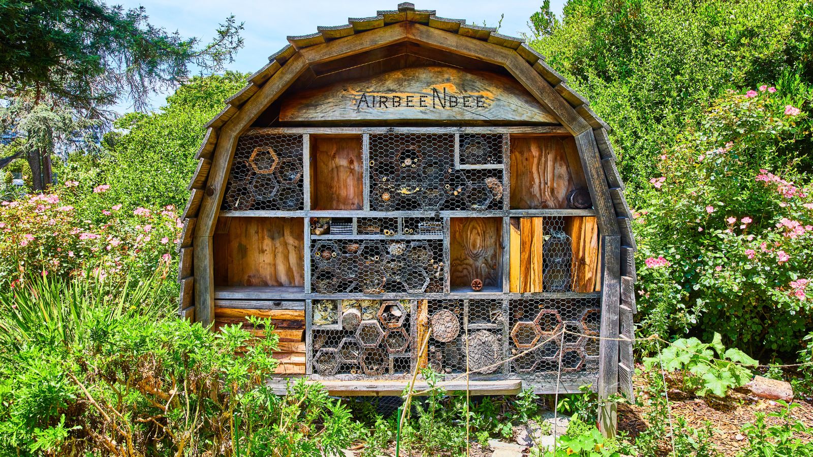 Insect hotel in the middle of a lush garden.