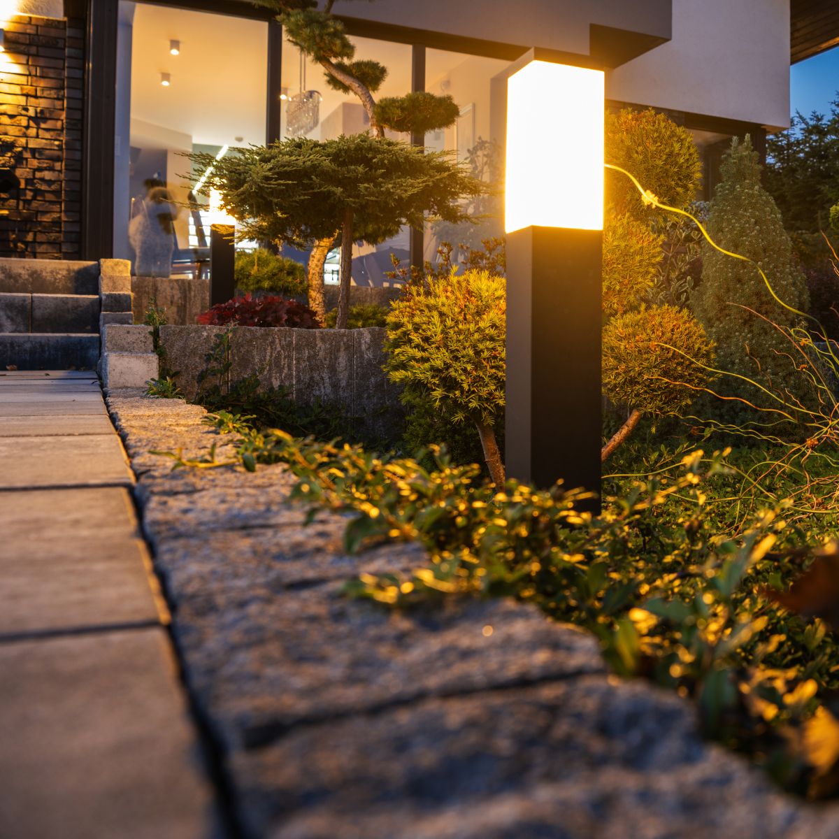 Modern square pole light in front of the house.