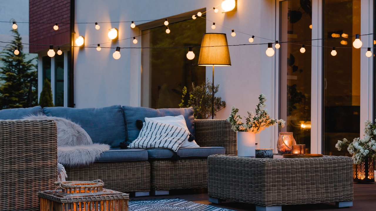 Summer evening on the patio of beautiful suburban house with lights in the garden garden